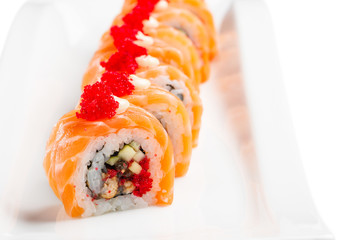 sushi rolls with salmon, eel, cucumber and tobiko on white plate