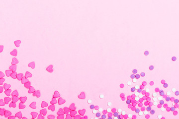 Pink heart shaped sprinkles on pink Valentines day background