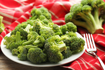 Broccoli in plate with napkin on grey wooden table