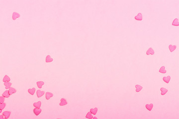 Fototapeta na wymiar Pink heart shaped sprinkles on pink Valentines day background