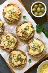 Baked ham, green olive and cheese sandwich with oregano, photographed overhead with natural light