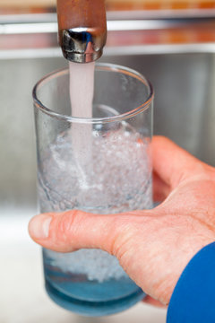 Filling up a glass with raw water from kitchen faucet