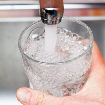 Filling up a glass with raw water from kitchen faucet