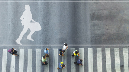 Fototapeta na wymiar top view of white symbol with business man run with briefcase on pedestrian crossroad and people walk cross street