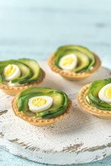 Tartlets with cream cheese, avocado and quail eggs