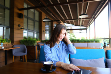 Young girl enjoying windy weather and playing with hair at cafe 