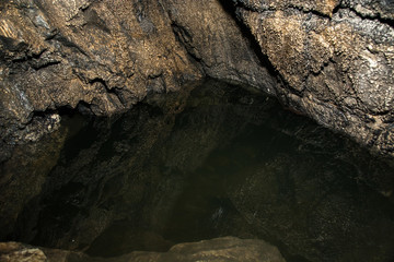 View inside a deep cave. Underground lake.