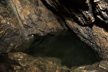 View inside a deep cave. Underground lake.