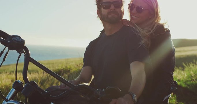 Lifestyle of couple on vintage motorcycle at sunset