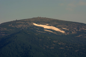 Snow on top of the mountain. Complete absence of vegetation. Evening time.