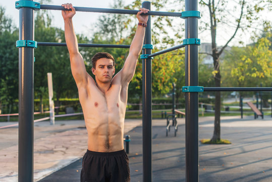 Fitnes man hanging on wall bars. Core cross training working out abs muscles