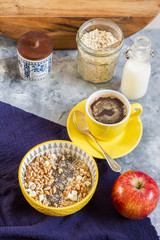 Porridge bowl. Oatmeal with apple and chia. Breakfast and coffee. Yellow bowl and cup of coffee.