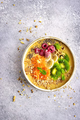 Orange banana smoothie topped with frozen berry and fresh fruit slices.Top view with copy space.