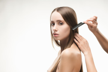 Obraz premium Beautiful young long-haired girl brushed by the stylist.