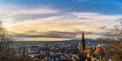 Fototapeta premium Germany, Baden-Wuerttemberg, Skyline of the City of Freiburg in warm evening sunlight from above extra large panorama