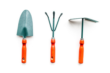 Gardening tools: spade, fork, hand cultivator, hoe on white background top view