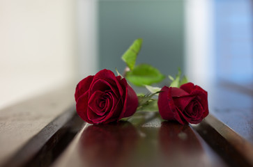 Roses for Valentine's Day are on a wooden table.