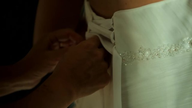 Bridesmaid helps zip up wedding dress