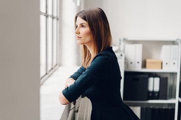 Pretty woman standing staring out of a window