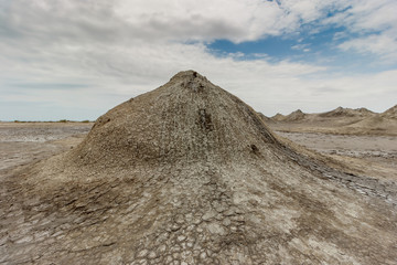 Fototapeta na wymiar Ancient warm mud volcanoes that swirl with dirt from the bowels of the earth.
