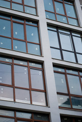 Beautiful modern apartment house. Rectangular windows reflect cold blue daylight.