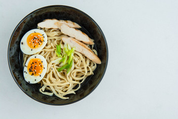 Traditional Japanese soup ramen with meat broth, asian noodles, seaweed, sliced chiken, eggs. Close up. Asian style food. Top view. Hot tasty ramen soup for dinner.