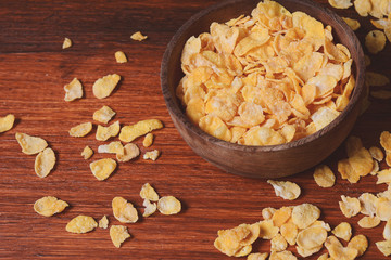 Top view of bowl full of cereals on wooden background