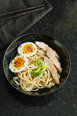 Traditional Japanese soup ramen with meat broth, asian noodles, seaweed, sliced chiken, eggs. Close up. Asian style food. Top view. Hot tasty ramen soup for dinner.