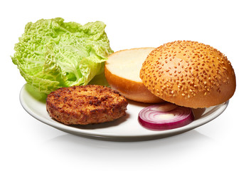 Hamburger, fresh bun, onion and lettuce on white plate