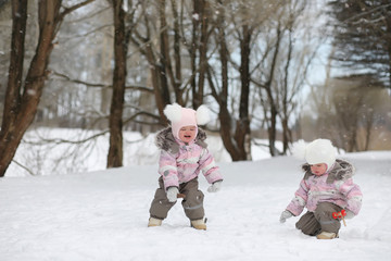Children walk in the park in winter. Winter forest a family with