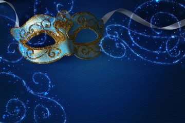 Image of elegant blue and gold venetian, mardi gras mask over blue background. © tomertu