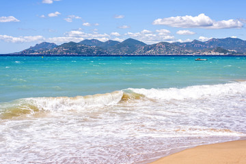 Daylight sunny view to blue sea and sand with traces from water