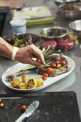 Chef cooking juicy beef steak at restaurant kitchen