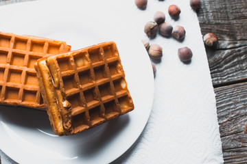 Waffle on a wooden background on a white napkin