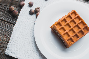 Waffle on a wooden background on a white napkin