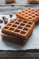 Waffle on a wooden background on a white napkin