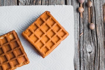 Waffle on a wooden background on a white napkin