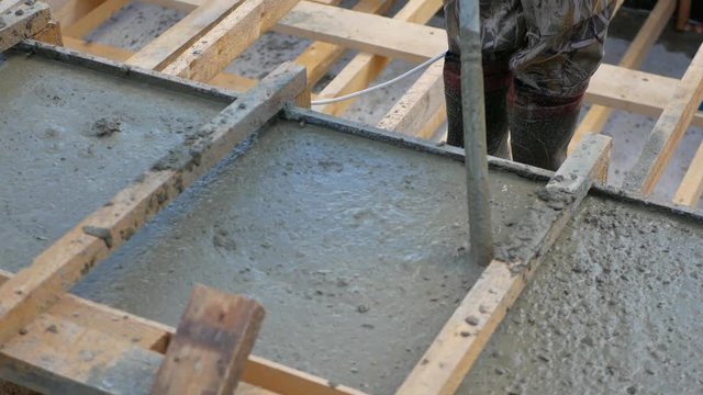 Builder On Formwork Foundation Uses The Vibrator To Concrete Has Left The Air