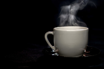 Moody White porcelain Coffee tea mug cup isolated on black background, with soft white steam smoke from fresh brewed coffee