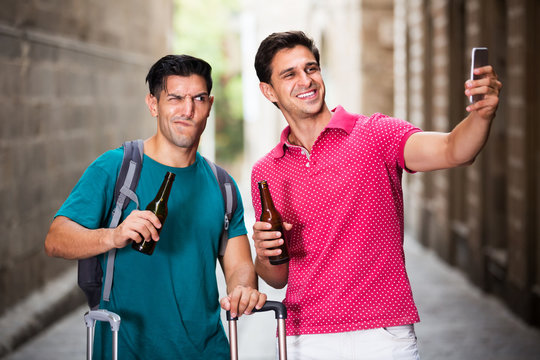 Men tourists walking with beer