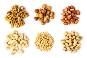 Six types of walnut, hazelnut, peanut, cashew, pine and pistachios on a white background.