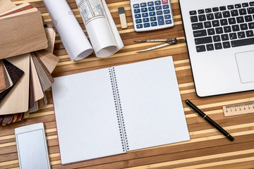 house plan with laptop, phone, wooden samples and pen