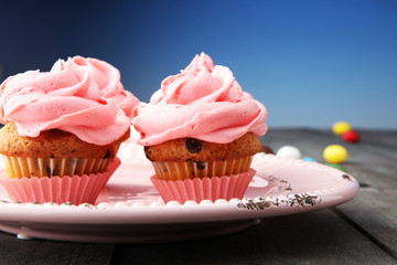 Tasty cupcakes on wooden background. Birthday cupcake in pink color