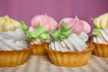 Pink and yellow cupcakes on pink background, sweet food