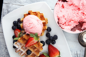 Plate of belgian waffles with strawberry ice cream, and fresh strawberries