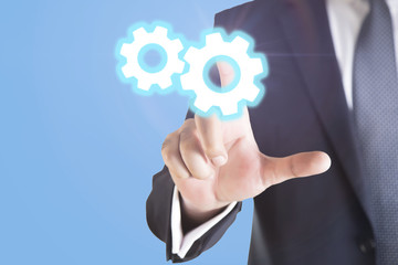 business man hand pressing a touch screen button. wheels as symbols of business man, Business concept 