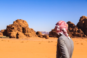 Fototapeta na wymiar Arab man seen from behind in the Wadi Rum desert in Jordan