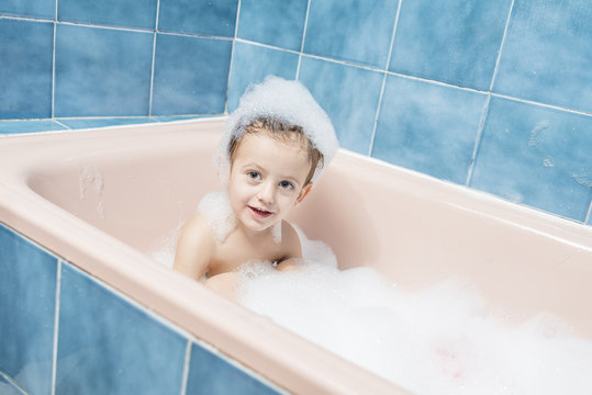 Smiling child playing in the bath