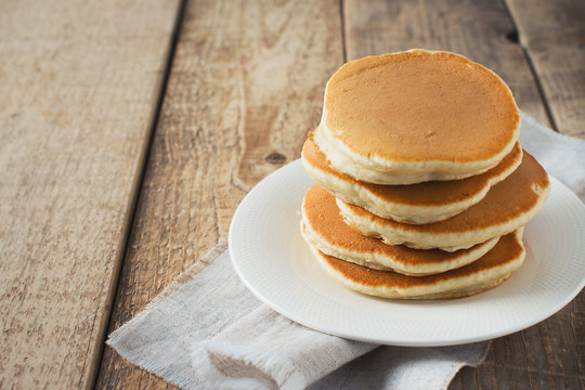 Pancakes day background, stack of homemade pancake over wooden table
