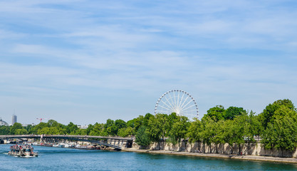 Naklejka premium The embankment of the Seine River, bridge Passerelle Solferino or Leopold Sedar Senghor and La Grande Roue (Ferris Wheel).Paris, France